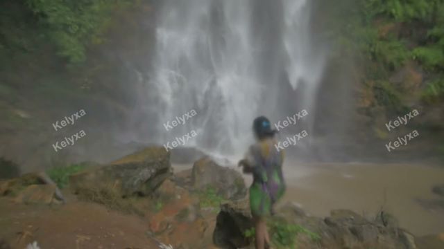 Hiker Standing Before Waterfall