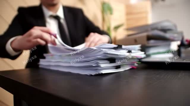 Businessman Sorting Paperwork at Desk