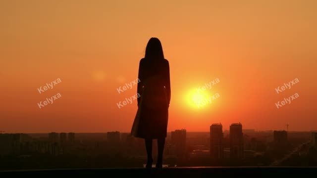 Woman Silhouetted at Sunset Skyline